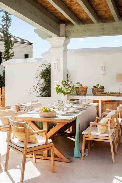 comedor de madera y barbaoca de obra en el jardin
